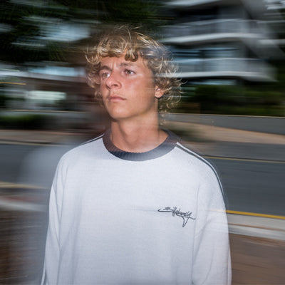 Blurred image of a model wearing a white Billabong t-shirt